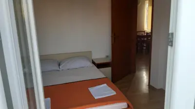 a small bedroom with a bed and a hallway at Apartman Petar in Budva