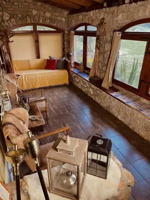 a room with a bed and a couch and windows at Village house Velimirović in Danilovgrad