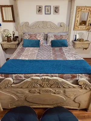 a bedroom with a large wooden bed with blue pillows at Village house Velimirović in Danilovgrad