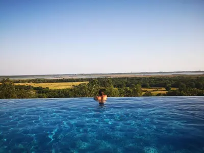 a person in a swimming pool in the water at Solana's View - Ferienhäuser in ruhiger Lage, mit einer einzigartigen Aussicht, Infinity Pool, Free Parking und Wlan in Ulcinj