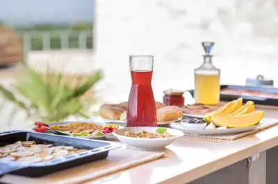 a table with plates of food and a bottle of beer at Solana's View - Ferienhäuser in ruhiger Lage, mit einer einzigartigen Aussicht, Infinity Pool, Free Parking und Wlan in Ulcinj
