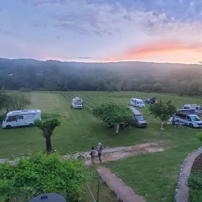 a group of people standing in a field with tents and vehicles at Purple Eye Camp & Winery in Podgorica