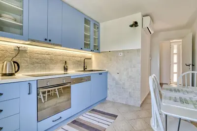 a kitchen with blue cabinets and a dining table at Eva's country house in Buljarica