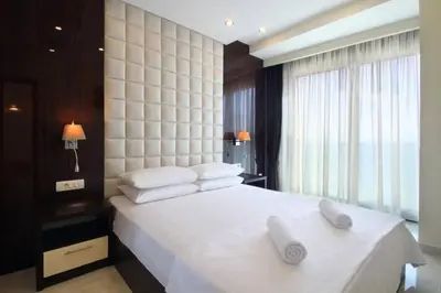 a bedroom with a large white bed with towels on it at BigMontenegro Shine in Budva