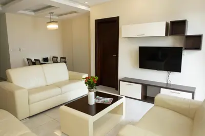 a living room with two white couches and a tv at BigMontenegro Shine in Budva
