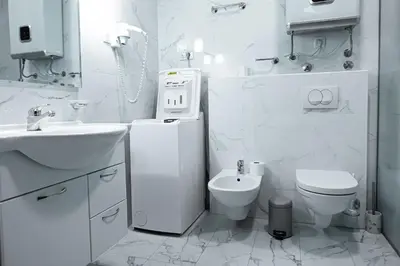 a white bathroom with a toilet and a sink at BigMontenegro Shine in Budva