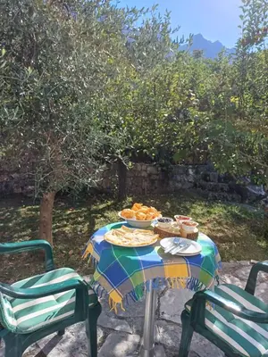 a table with plates of food on it with two chairs at DOLCE NOTTE rooms in Virpazar
