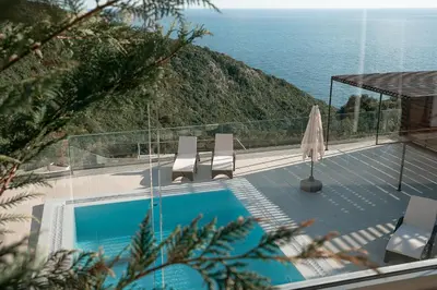a swimming pool with chairs and a view of the ocean at Villa Cape Montenegro on Cliffside in Kotor