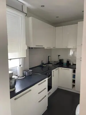 a kitchen with white cabinets and black counter tops at Apartment Ritter in Budva