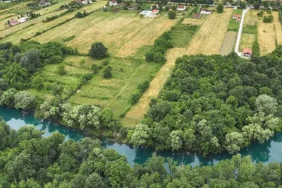 an aerial view of a river with trees and houses at Pool & River House - Lazara in Danilovgrad