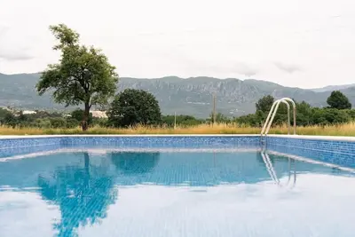a swimming pool with a view of mountains at Pool & River House - Lazara in Danilovgrad