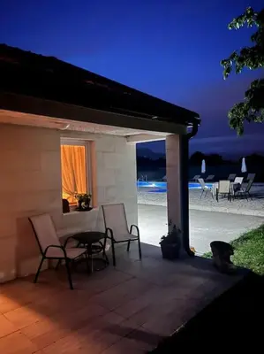 a patio with chairs and a table and a window at Pool & River House - Lazara in Danilovgrad