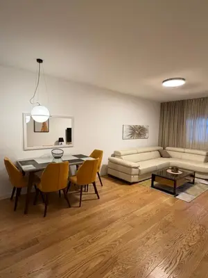 a living room with a table and a couch at White Homes 45 • Central Point in Podgorica