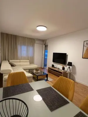 a living room with a couch and a table at White Homes 45 • Central Point in Podgorica