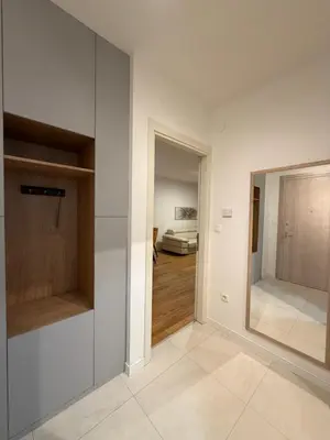 a room with white walls and a hallway with a mirror at White Homes 45 • Central Point in Podgorica