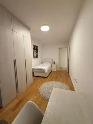 a room with a bedroom with a bed and a table at White Homes 45 • Central Point in Podgorica