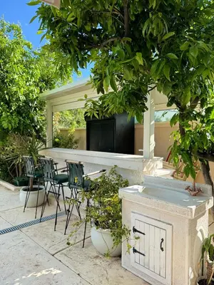 a patio with a table and chairs under a tree at Villa La Vida in Budva