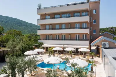 an external view of a hotel with umbrellas and a swimming pool at Villa La Vida in Budva