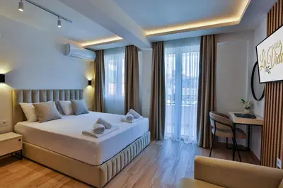 a hotel room with a bed and a desk and window at Villa La Vida in Budva