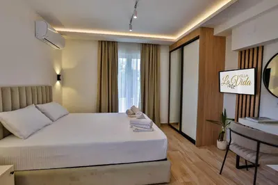 a bedroom with a large white bed and a desk at Villa La Vida in Budva