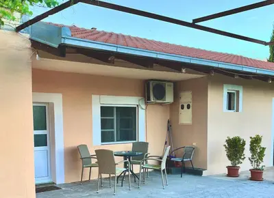a patio with chairs and a table in front of a house at Apartman Boljević in Podgorica
