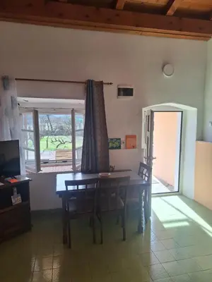 a dining room with a table and chairs and a window at Apartman Boljević in Podgorica