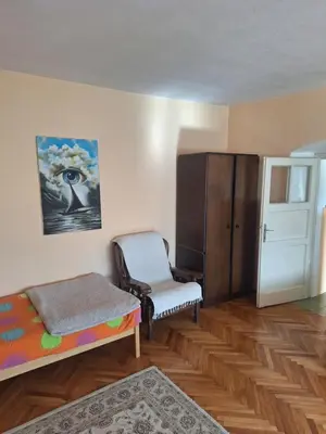 a bedroom with a bed and a chair and a cabinet at Apartman Boljević in Podgorica