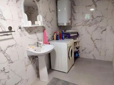 a bathroom with a sink and a washing machine at Apartman Boljević in Podgorica