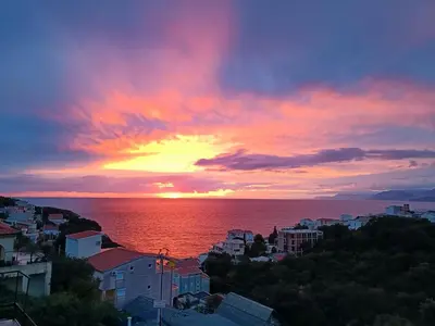 a sunset over the ocean in a city at Carefree Apartments in Ulcinj