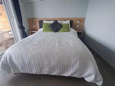 a bedroom with a white bed with green pillows at Carefree Apartments in Ulcinj