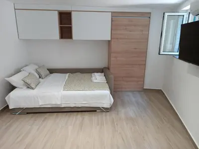 a bedroom with a bed and a wooden floor at Studio Apartment Danka Old Town Budva in Budva