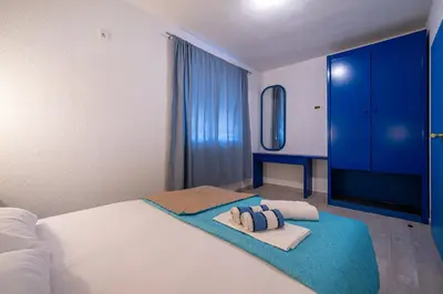 a bedroom with a bed with a blue dresser and towels at MAS Apartments in Kotor