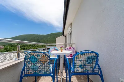 a table and chairs on a balcony with a view at MAS Apartments in Kotor