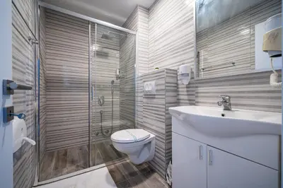 a bathroom with a toilet and a sink and a shower at MAS Apartments in Kotor