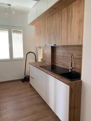 a kitchen with a sink and wooden cabinets at D&D apartments in Sutomore