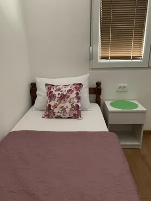 a bedroom with a bed with a pillow and a table at D&D apartments in Sutomore