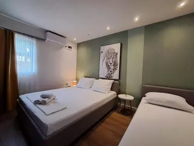 a bedroom with two beds and a painting on the wall at Garden Apartments in Ulcinj