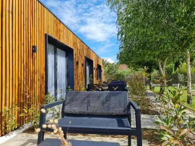 a black bench sitting in front of a yellow building at Garden Apartments in Ulcinj
