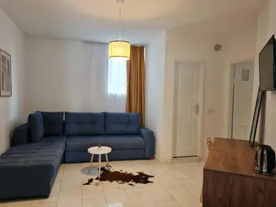 a living room with a blue couch and a table at Garden Apartments in Ulcinj