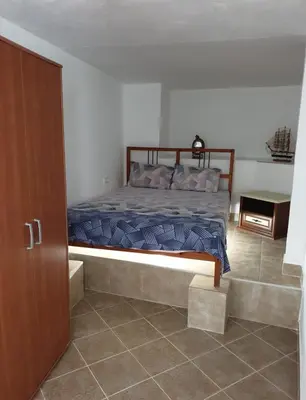 a bedroom with a bed and a table in it at Smurf's house in Budva