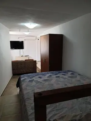 a bedroom with a bed and a cabinet and a television at Smurf's house in Budva