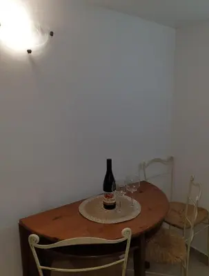 a table with a bottle of wine and two glasses on it at Smurf's house in Budva