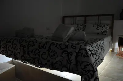 a bedroom with a bed with a black and white comforter at Smurf's house in Budva