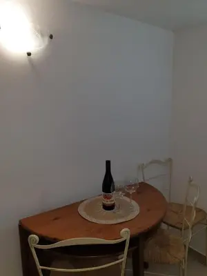 a bottle of wine sitting on a table with two glasses at Smurf's house in Budva