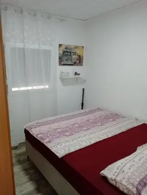 a bedroom with a bed and a window at Apartman Jovanovic in Sutomore