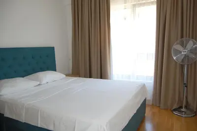 a bedroom with a bed with a fan and a window at Status-M Apartments 89 in Becici