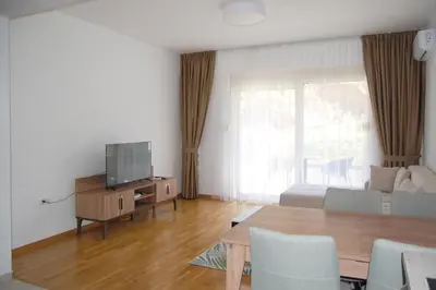 a living room with a bed and a tv and a table at Status-M Apartments 89 in Becici