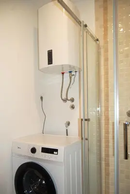 a washing machine in a bathroom next to a shower at Status-M Apartments 89 in Becici