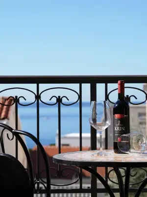 a table with a bottle of wine and a glass at Apartman Bonaca in Pržno