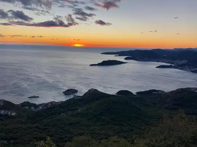 a sunset over a body of water with islands at Apartman Bonaca in Pržno